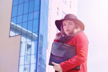 Wall Mural - Pretty girl on a walk in red coat in the city