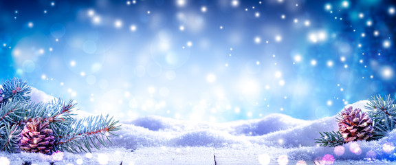 fir branches and frosty pinecones on snowy wooden table with wintry blizzard background - christmas 