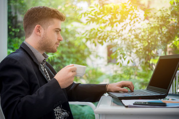 businessman working with laptop computer at coffee shop in the morning 