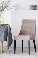 Wall Mural - Stylish chair next to dining table with grey tablecloth in trendy dining room interior