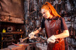 redhead ginger woman blacksmith portrait in workshop