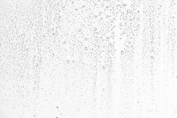 white isolated background water drops on the glass / wet window glass with splashes and drops of wat