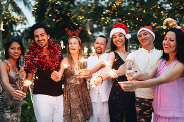 Wall Mural - Group of friends celebrating Christmas with sparkles and champagne