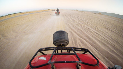 Girls drive quad biike.Desert in Egypt. Sharm el Sheikh. Sand and Sand Borkhan. Rock and sunset. Quad Cycle Travel. Excursion with people.Extreme sports & fun outdoors activities