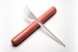 © romsvetnik - A plastic fork lies crosswise on a hot dog sausage. Ban plastic dishes. The concept of fast food, GMOs, hunger or lack of food. Ecological problem. White background. Copy space.