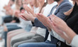 © ASDF - group of young people applauding sitting in the conference room.