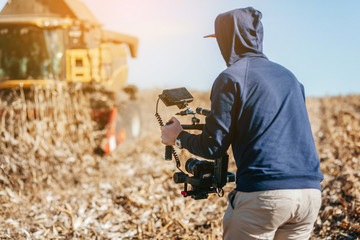 The videographer is working on the report in the field