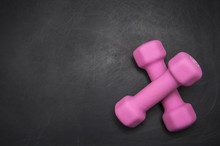 Two Pink Dumbbell On A Gray Background