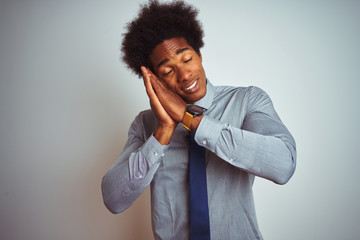 Wall Mural - American business man with afro hair wearing shirt and tie over isolated white background sleeping tired dreaming and posing with hands together while smiling with closed eyes.