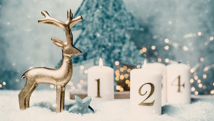 advent candles 1, 2,3,4 in front of concrete background and reindeer in the snow with colorful light