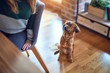 © Krakenimages.com - Young beautiful woman smiling happy and confident. Sitting on chair with dog