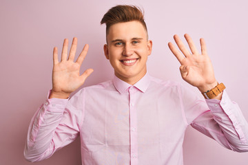 Young handsome businessman wearing elegant shirt standing over isolated pink background showing and pointing up with fingers number nine while smiling confident and happy.