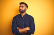 © Krakenimages.com - Young handsome indian businessman wearing shirt over isolated yellow background smiling looking to the side and staring away thinking.