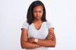 © Krakenimages.com - Beautiful young african american woman wearing casual t-shirt over isolated background skeptic and nervous, disapproving expression on face with crossed arms. Negative person.