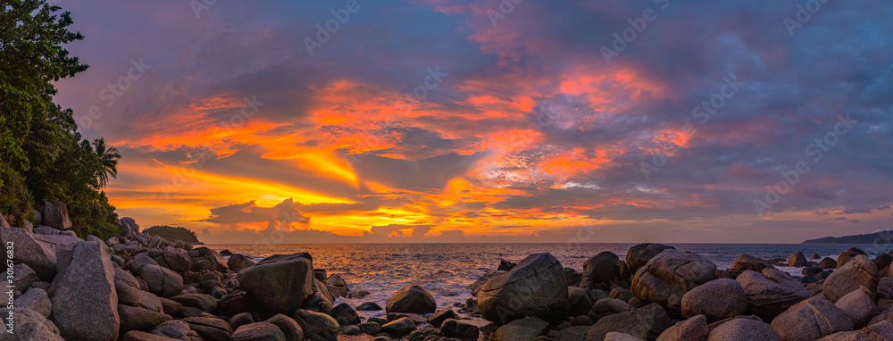 panorama sunset at Laem Sai cape. Many small and large stones surround Laem Sai cape from Karon Beach to Kata Beach.. - obrazy, fototapety, plakaty 