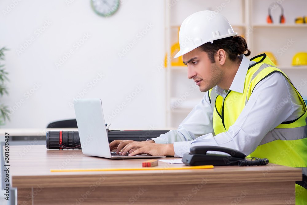 Young male architect working in the office - obrazy, fototapety, plakaty 