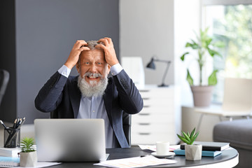 Canvas Print - Angry mature man working in office