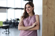 © ty - Attractive business woman smiling while standing in the office.