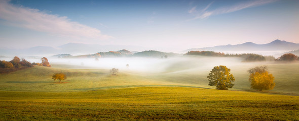 Fall in Slovakia. Meadows and fields landscape near Poniky. Autumn colored trees at sunrise