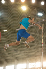 Pole vault training in the sports stadium - young fit man falling down after the jump