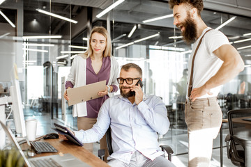 Wall Mural - senior manager having a meeting with office workers standing together near the working place in the 