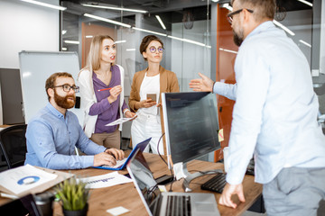 Wall Mural - group of diverse colleagues working in the modern office, having discussion or small conference on a