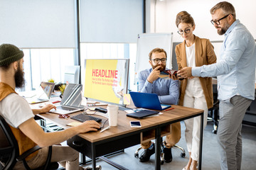Wall Mural - group of diverse creative people having a small discussion, working as a web designers in the modern