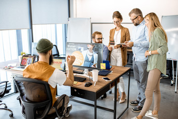 Wall Mural - group of diverse creative people having a small discussion, working as a web designers in the modern