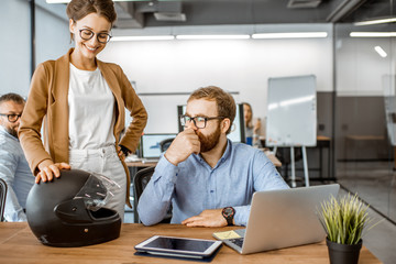 Wall Mural - two young colleagues talking at the working place, solving some working moments in the busy office o