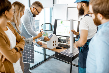 Poster - Group of alternative energy engineers discussing a project with a worker during a meeting in the office. Green energy development concept