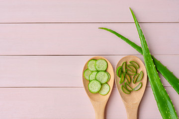 Wall Mural - Aloevera and cucumber with aloe vera leaf isolated on pink wood table background.