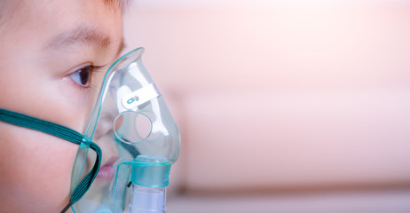 closeup asian face little children boy using steam inhaler nebulizer mask inhalation