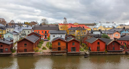 Wall Mural - Porvoo town, Finland. Old red wooden houses on the river coast on a cloudy day