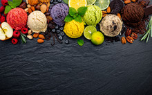 Various Of Ice Cream Flavor Ball Blueberry ,lime ,pistachio ,almond ,orange ,chocolate And Vanilla Set Up On Dark Stone Background . Summer And Sweet Menu Concept.