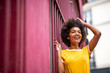 © mimagephotos - happy african American woman laughing outside with hand in hair
