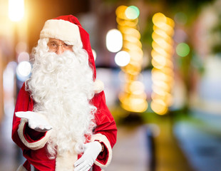 Canvas Print - Middle age handsome man wearing Santa Claus costume and beard standing smiling cheerful offering palm hand giving assistance and acceptance.