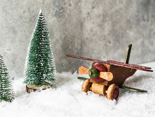 Christmas composition with a wooden vintage airplane and Christmas tree in snow