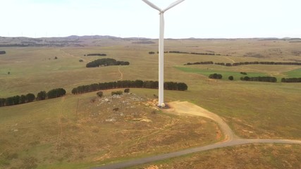 Wall Mural - aerial view rising up over a large wind turbine moving to create kinetic energy for renewable energy