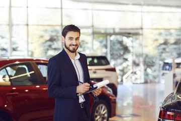 Wall Mural - A car dealer standing in a showroom.