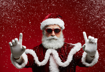 Wall Mural - Waist up portrait of cool Santa wearing sunglasses and smiling at camera ready to enjoy Christmas party in snow