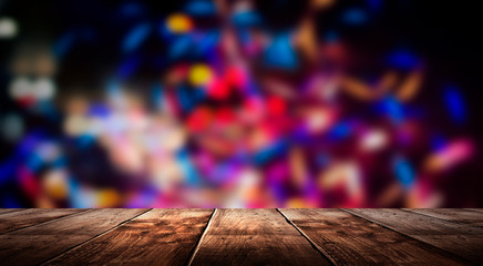 Wall Mural - Wooden table, blurred bokeh background background. Neon light, night view, close-up. The general background of the interior, a dark background.