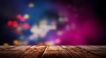 Wall Mural - Wooden table, blurred bokeh background background. Neon light, night view, close-up. The general background of the interior, a dark background.