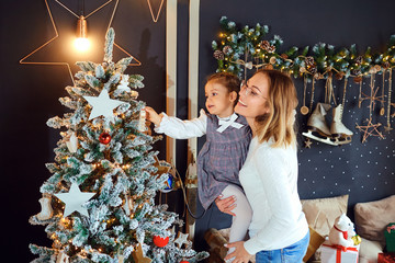 Wall Mural - Mother and daughter decorate the Christmas tree.