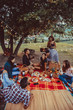 © oneinchpunch - Group of friends eating in the nature