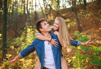 Wall Mural - Happy couple guy and girl in forest park have fun together, people in love, concept of freedom and relationships