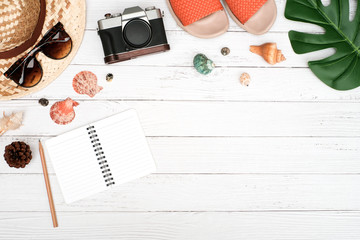 Flat lay, Top view traveler concept on white wooden table desk background with copy space, hat and glass, blank notepad and supplies 