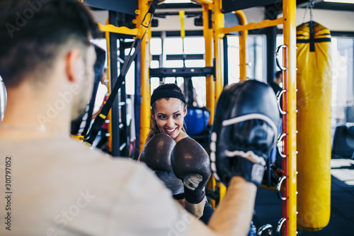 фотографія Young attractive woman with instructor on kickboxing training