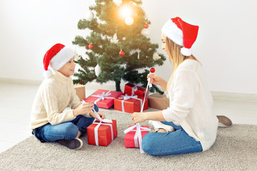 Wall Mural - Single parent and holidays concept - Portrait of mother and son celebrating christmas at home on christmas eve