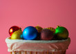 Christmas toys in a wooden basket on a pink background