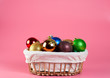 Christmas toys in a wooden basket on a pink background
